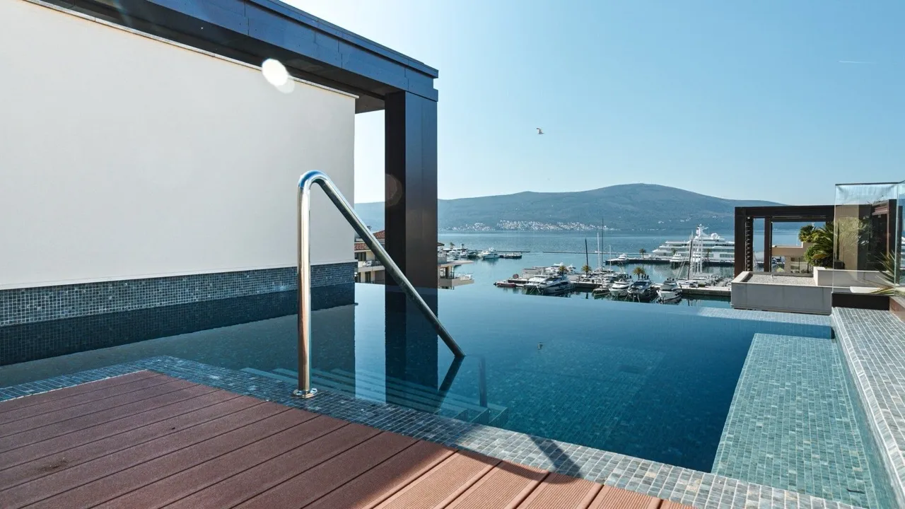 Infinity-Pool auf der Terrasse einer Luxuswohnung in Porto Montenegro, Tivat, mit Blick auf die Marina und Yachten, Montenegro.