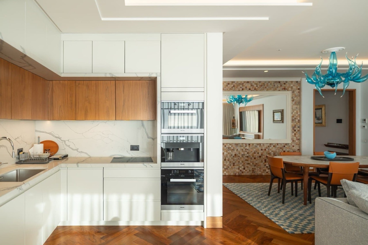 Современная кухня с техникой Miele в квартире в Порто Монтенегро, Тиват, Черногория: мраморный фартук и обеденная зона.