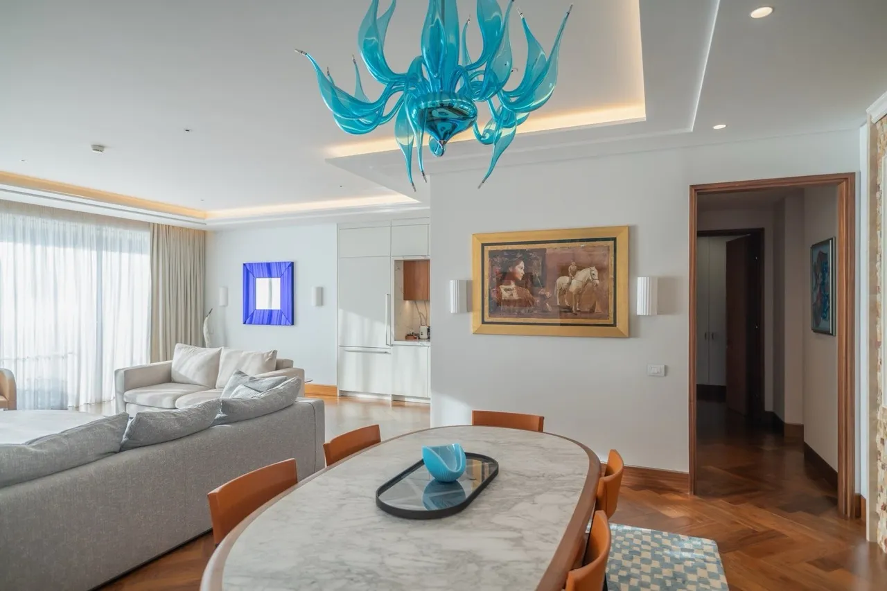 Wohnzimmer mit Essbereich und Designer-Kronleuchter in einer Wohnung im exklusiven Wohnkomplex Porto Montenegro, Tivat, Montenegro.