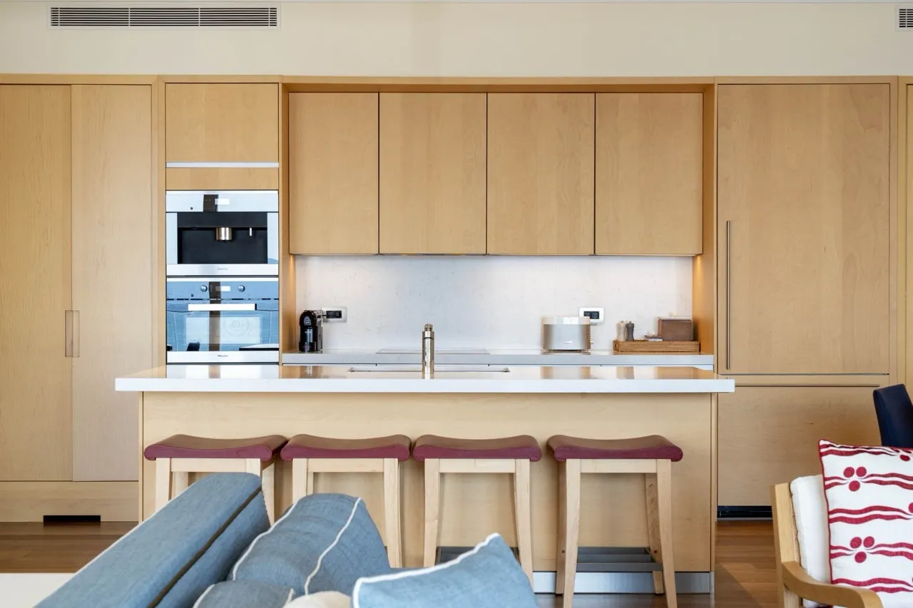 Moderne Küche mit Holzfronten und Bartheke in einer Wohnung in Tivat, Montenegro. Integrierte Miele-Geräte.