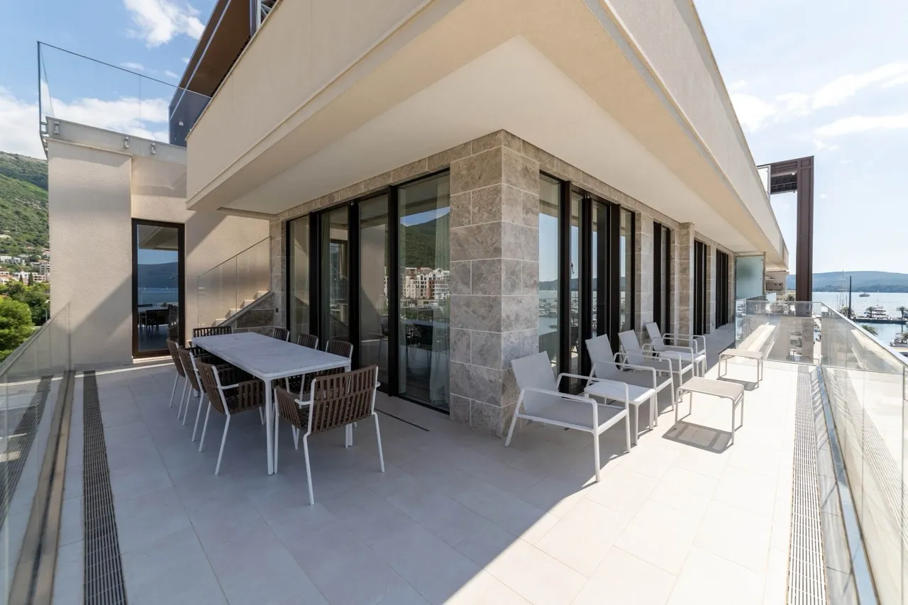 Geräumige Terrasse der Wohnung in Tivat, Montenegro, mit Essbereich, modernen Möbeln und Panoramablick auf das Meer.