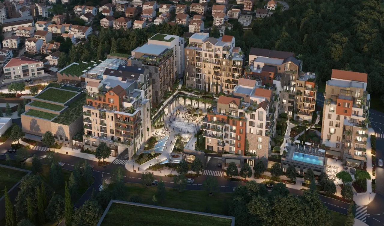 Luftaufnahme eines modernen Wohnkomplexes mit zentralem Platz und Parkplatz.