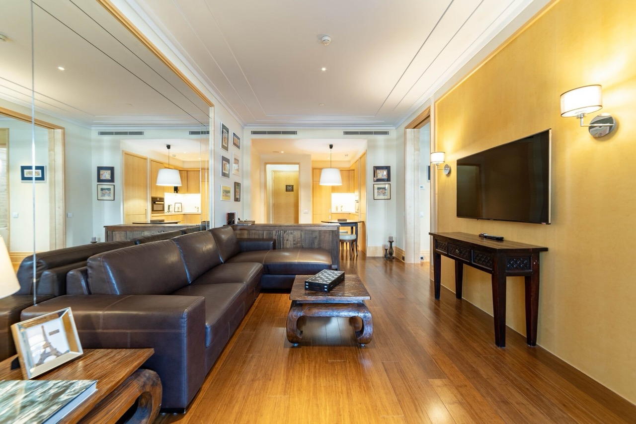 Dnevna soba sa kožnom sofom i drvenim nameštajem u stanu kompleksa Porto Montenegro, Tivat, Crna Gora.