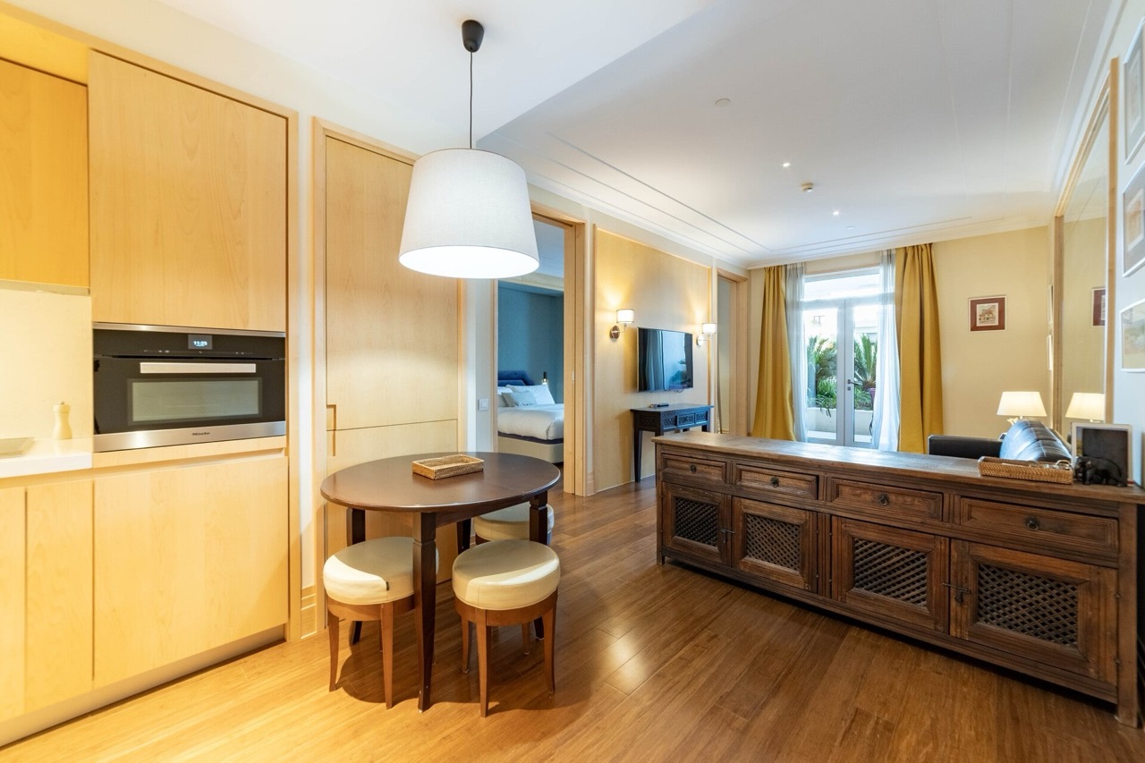 Dnevna soba s kuhinjom u apartmanima Porto Montenegro, Tivat, Crna Gora: drveni nameštaj, trpezarijski deo i terasa.