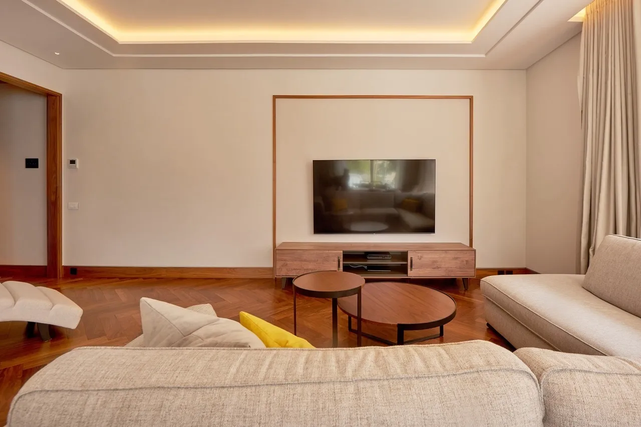 Modernes Wohnzimmer in einer Wohnung in Porto Montenegro, Tivat, Montenegro: Fischgrätparkett, TV-Bereich und stilvolle Möbel.
