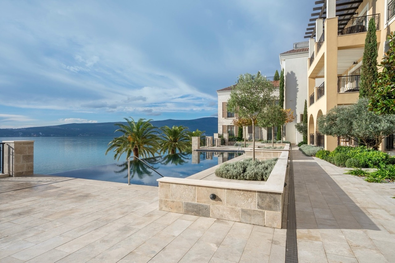 Infiniti bazen s pogledom na more i planine kod elitnog stambenog kompleksa u Porto Montenegru, Tivat, Crna Gora.