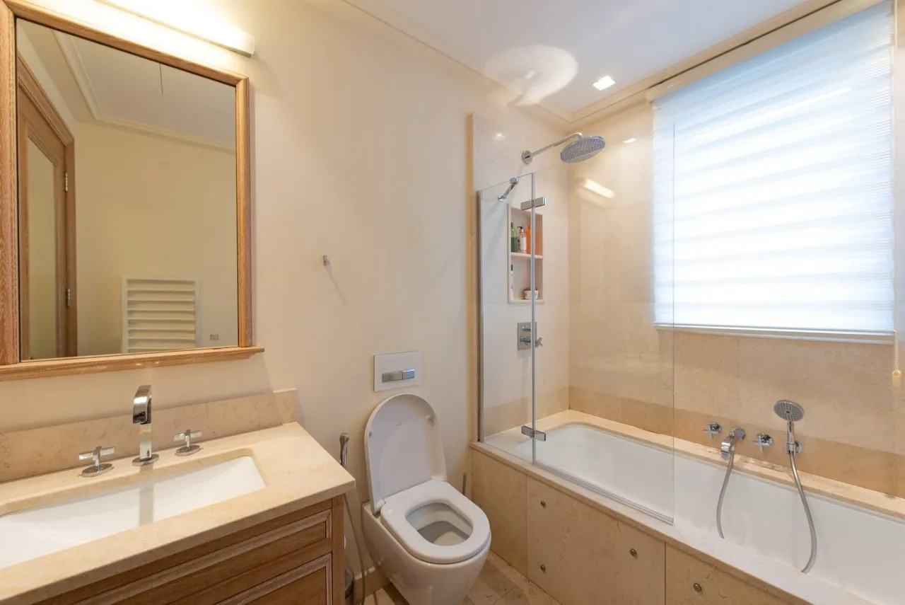 Modernes Badezimmer mit Steinverkleidung in der Wohnung im ЖК Porto Montenegro, Tivat, Montenegro: Badewanne und Dusche.