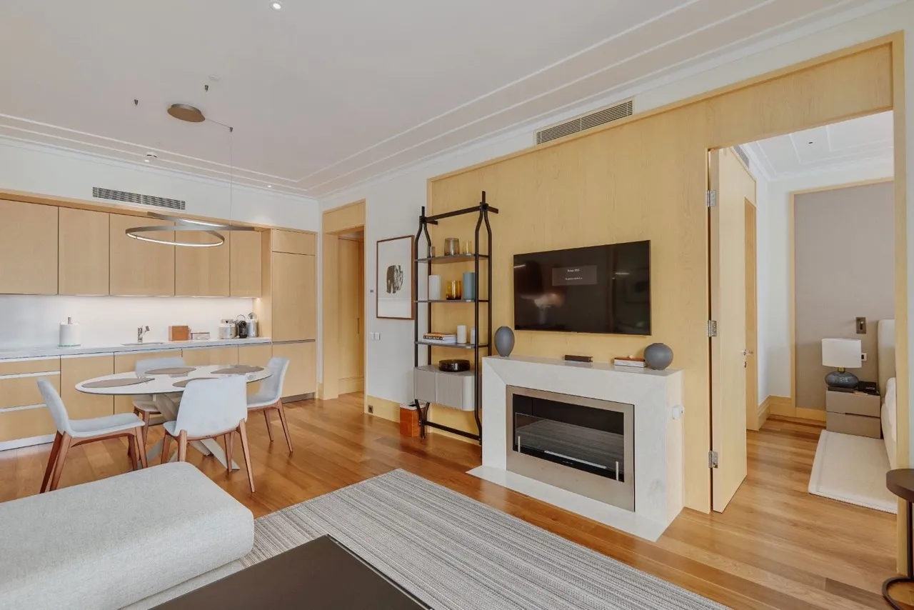 Wohnzimmer mit Kamin und Küche in einer Wohnung in Porto Montenegro, Tivat, Montenegro: modernes Interieur, helles Holz.