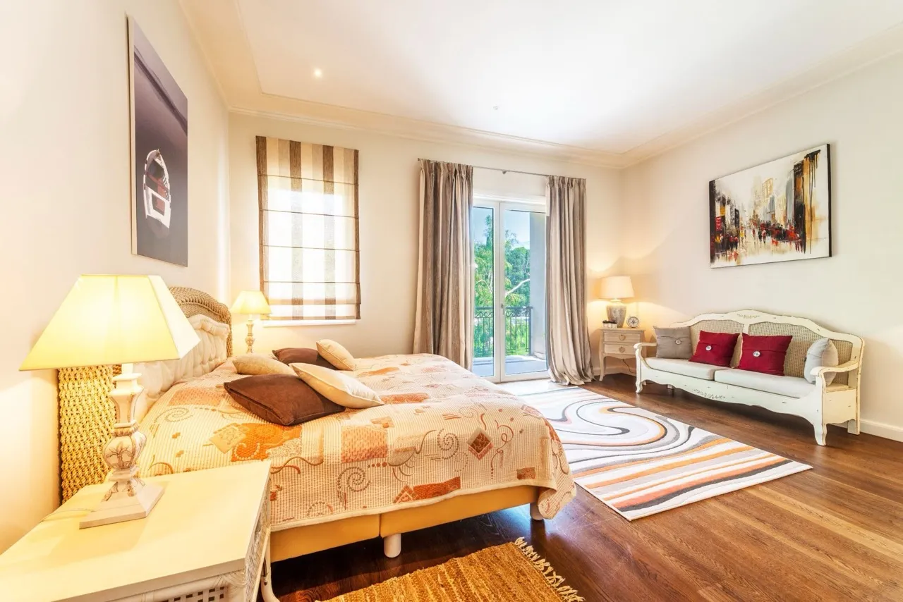 Helles Schlafzimmer mit Doppelbett und Sofa in der Wohnung Porto Montenegro, Tivat, Montenegro, mit Zugang zum Balkon.