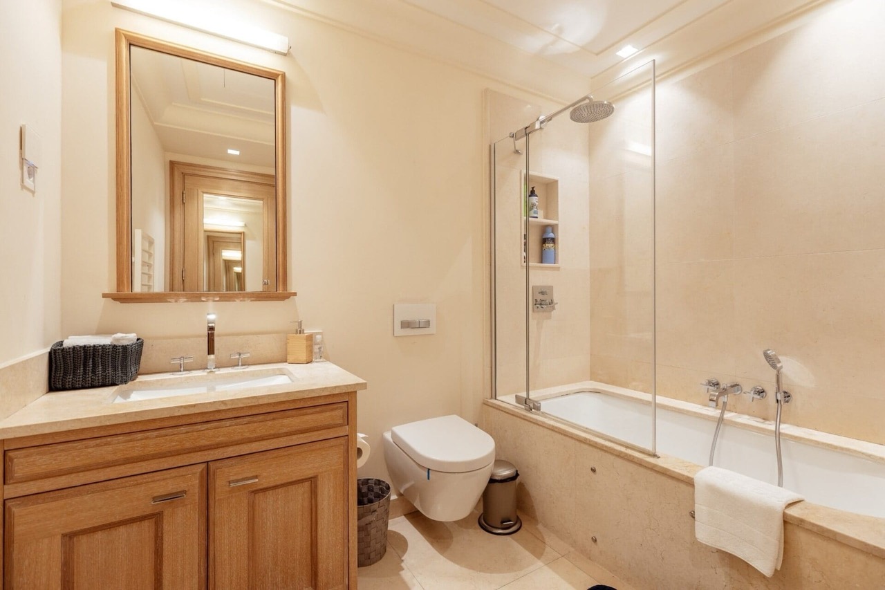 Современная ванная комната с отделкой из бежевого камня в квартире Porto Montenegro, Тиват, Черногория.