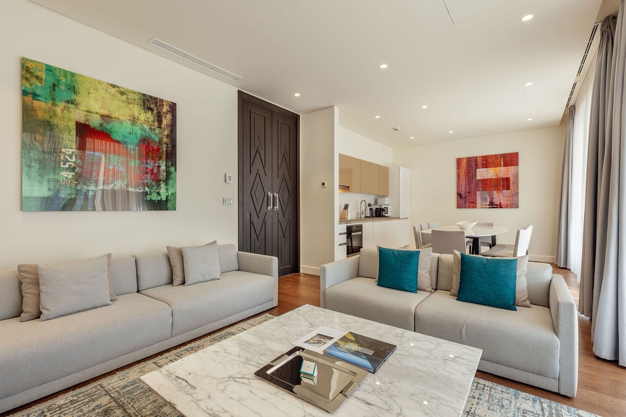 Modernes Wohnzimmer mit Küche in den Portonovi Apartments, Kumbor, Montenegro: helle Möbel, Marmortisch und Dekor.