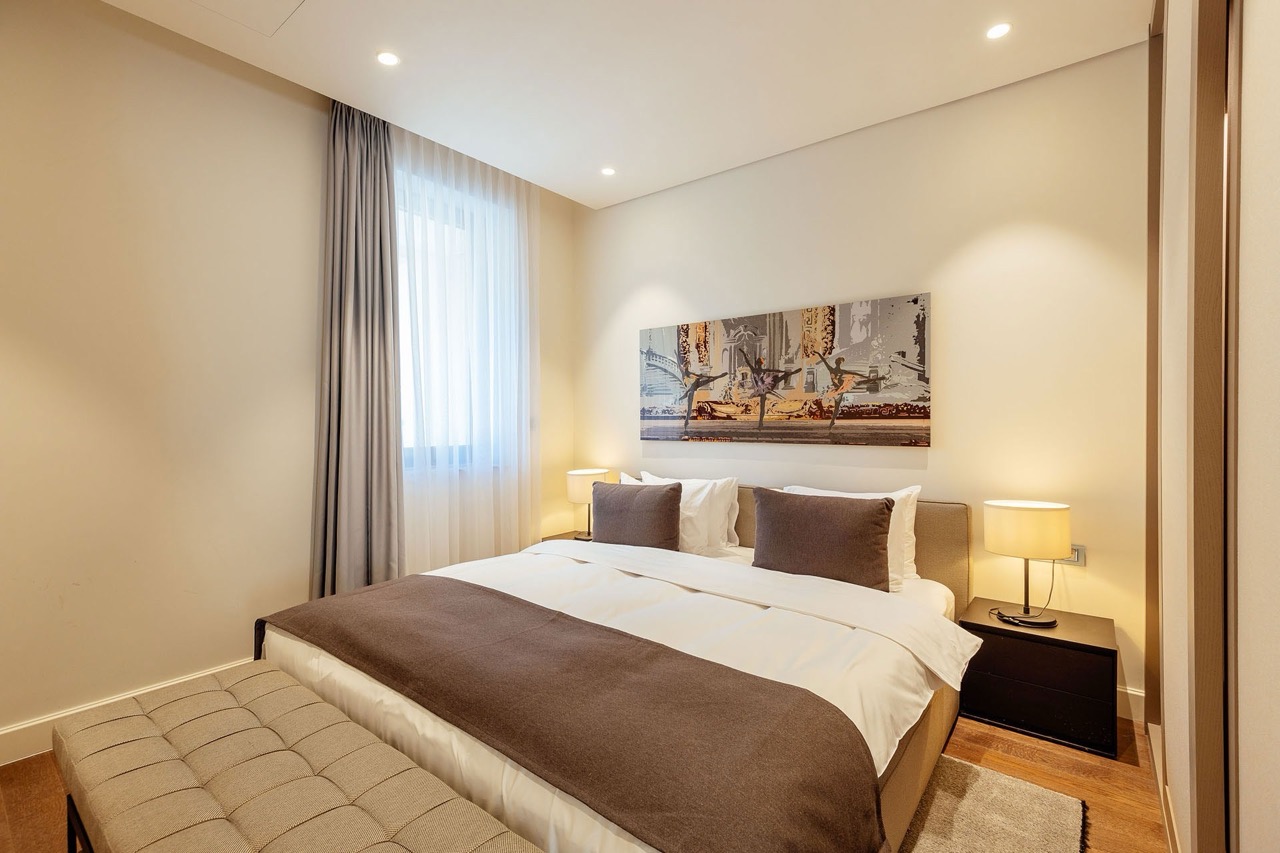 Modernes Schlafzimmer in der Wohnung Portonovi, Kumbor, Montenegro: Doppelbett, gepolsterte Bank und stilvolle Dekoration.