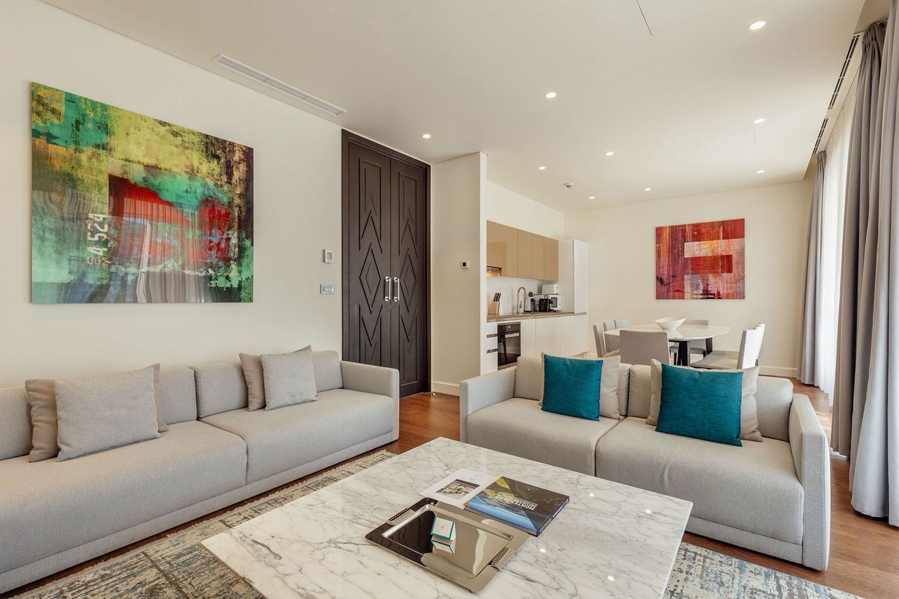 Modernes Wohnzimmer mit Küche in den Portonovi Apartments, Kumbor, Montenegro: helle Möbel, Marmortisch und Dekor.