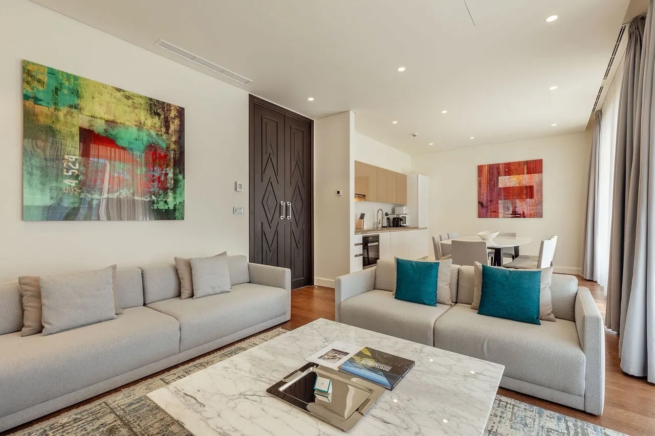 Modernes Wohnzimmer mit Küche in den Portonovi Apartments, Kumbor, Montenegro: helle Möbel, Marmortisch und Dekor.