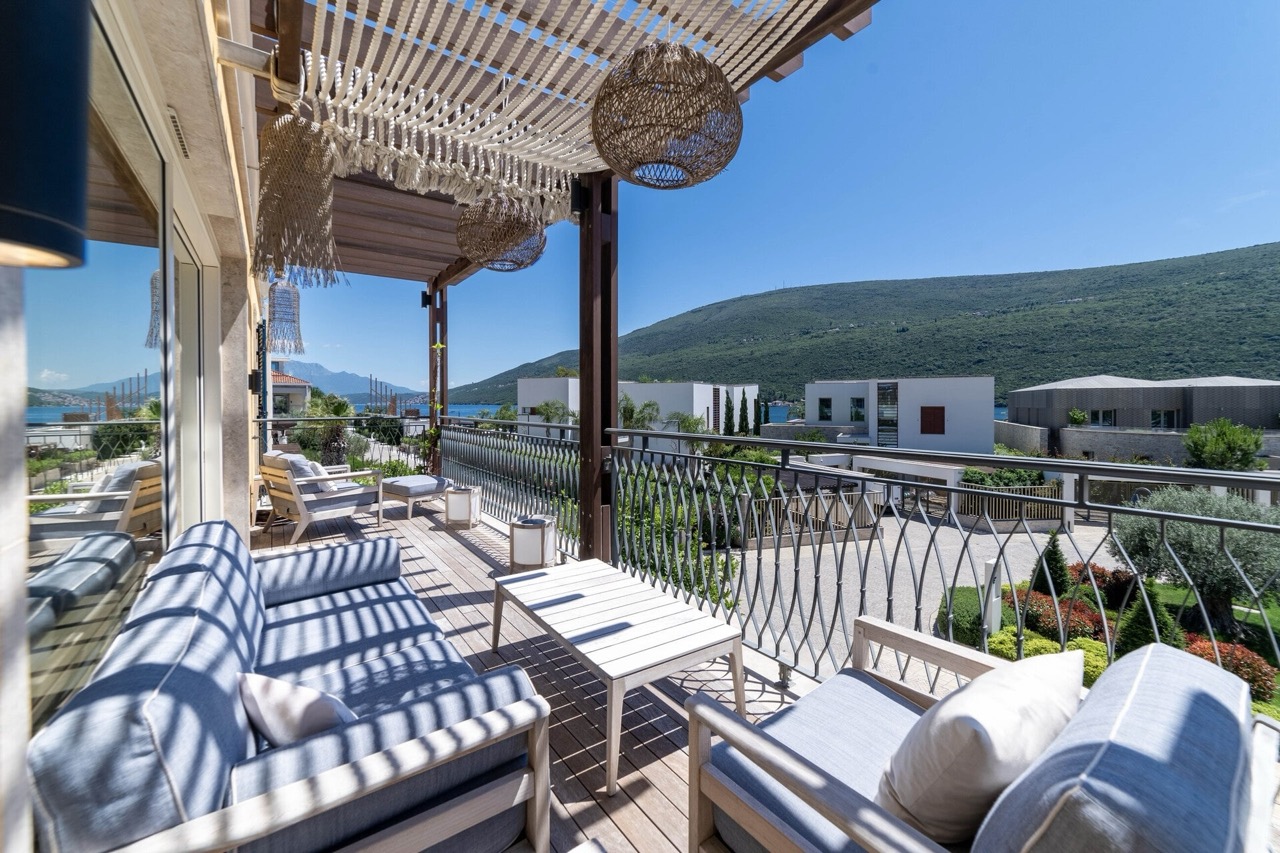 Terrasse mit Rattanmöbeln und Meerblick in der Wohnanlage Portonovi, Kumbor, Montenegro.