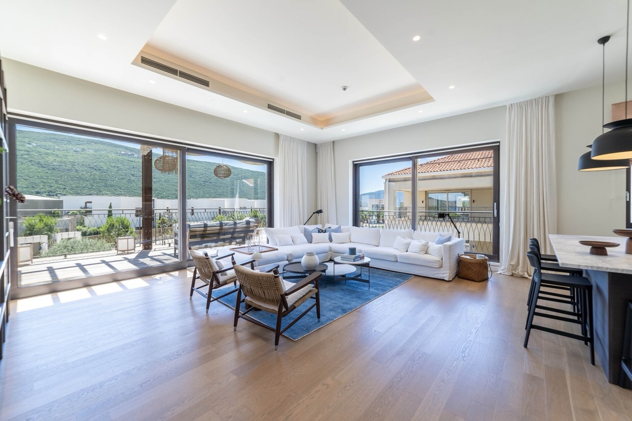 Modernes Wohnzimmer in Portonovi, Kumbor, Montenegro: Panoramafenster, helle Möbel, Terrasse mit Bergblick.