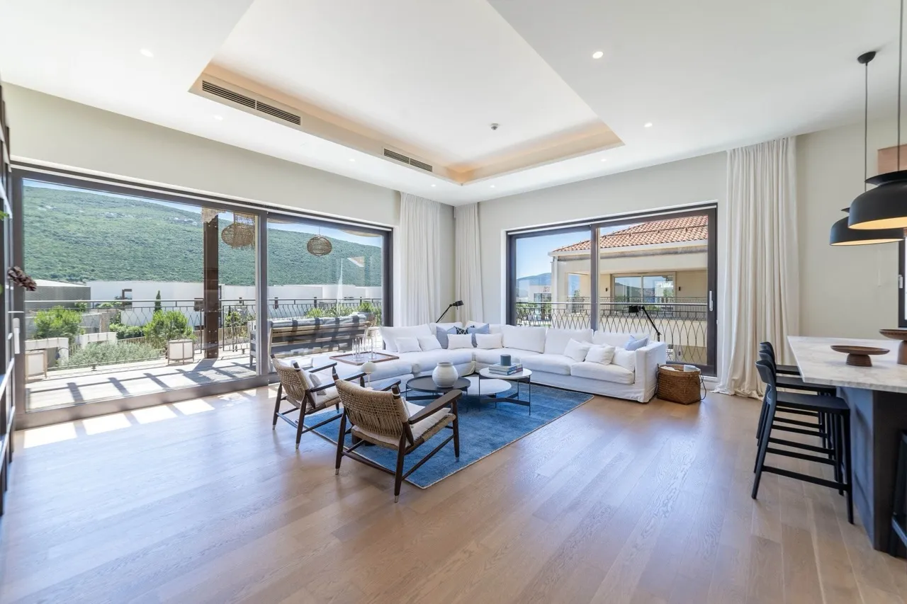 Modernes Wohnzimmer in Portonovi, Kumbor, Montenegro: Panoramafenster, helle Möbel, Terrasse mit Bergblick.