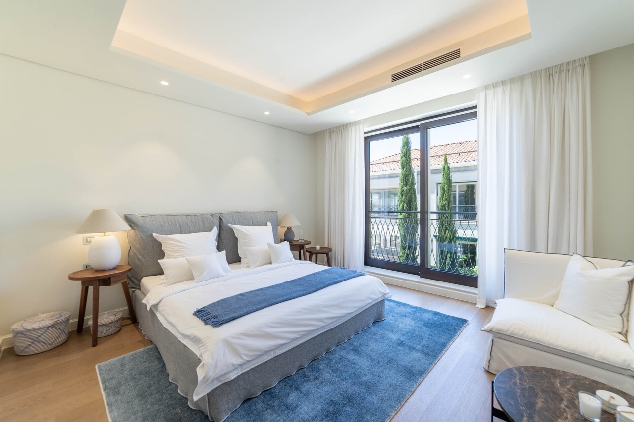 Modernes Schlafzimmer in der Wohnung Portonovi, Kumbor, Montenegro: Doppelbett, Panoramafenster und Blick auf Zypressen.