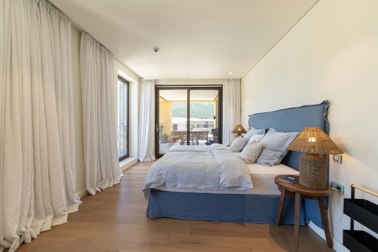 Gemütliches Schlafzimmer mit Doppelbett und Zugang zur Terrasse in den Portonovi Apartments, Kumbor, Montenegro.