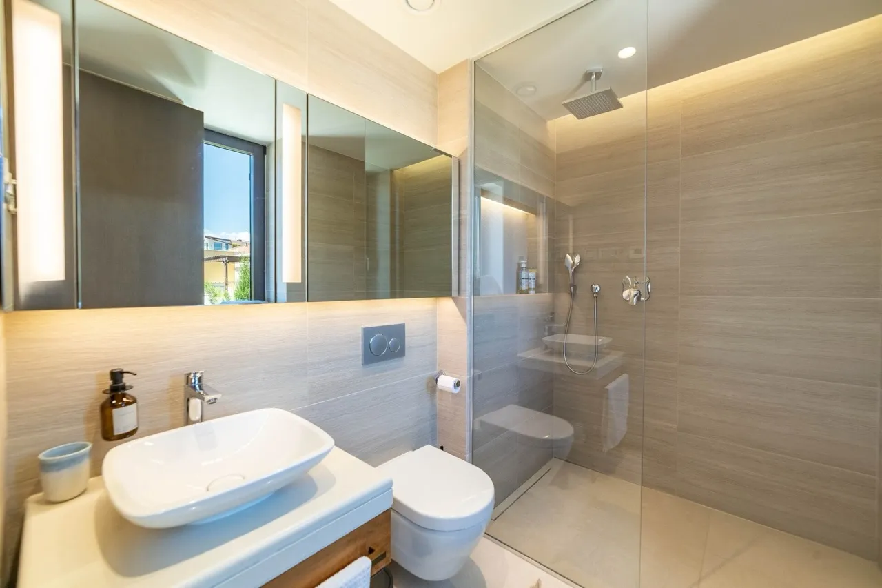 Modernes Badezimmer in der Wohnung Portonovi, Kumbor, Montenegro: Duschkabine, Aufsatzwaschbecken und Beleuchtung.