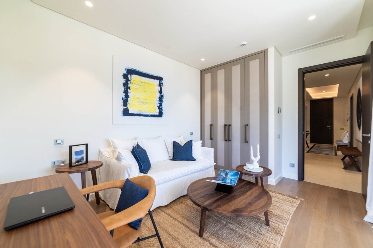 Modernes Wohnzimmer mit weißem Sofa und Holzmöbeln in einer Wohnung der Anlage Portonovi, Kumbor, Montenegro.