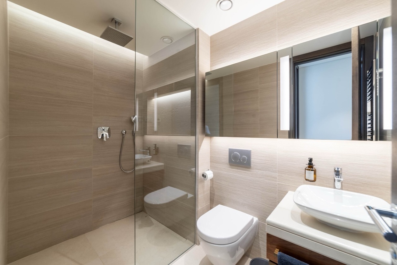 Modernes Badezimmer in der Wohnung Portonovi, Kumbor, Montenegro: Duschkabine, wandhängendes WC und stilvolles Waschbecken.