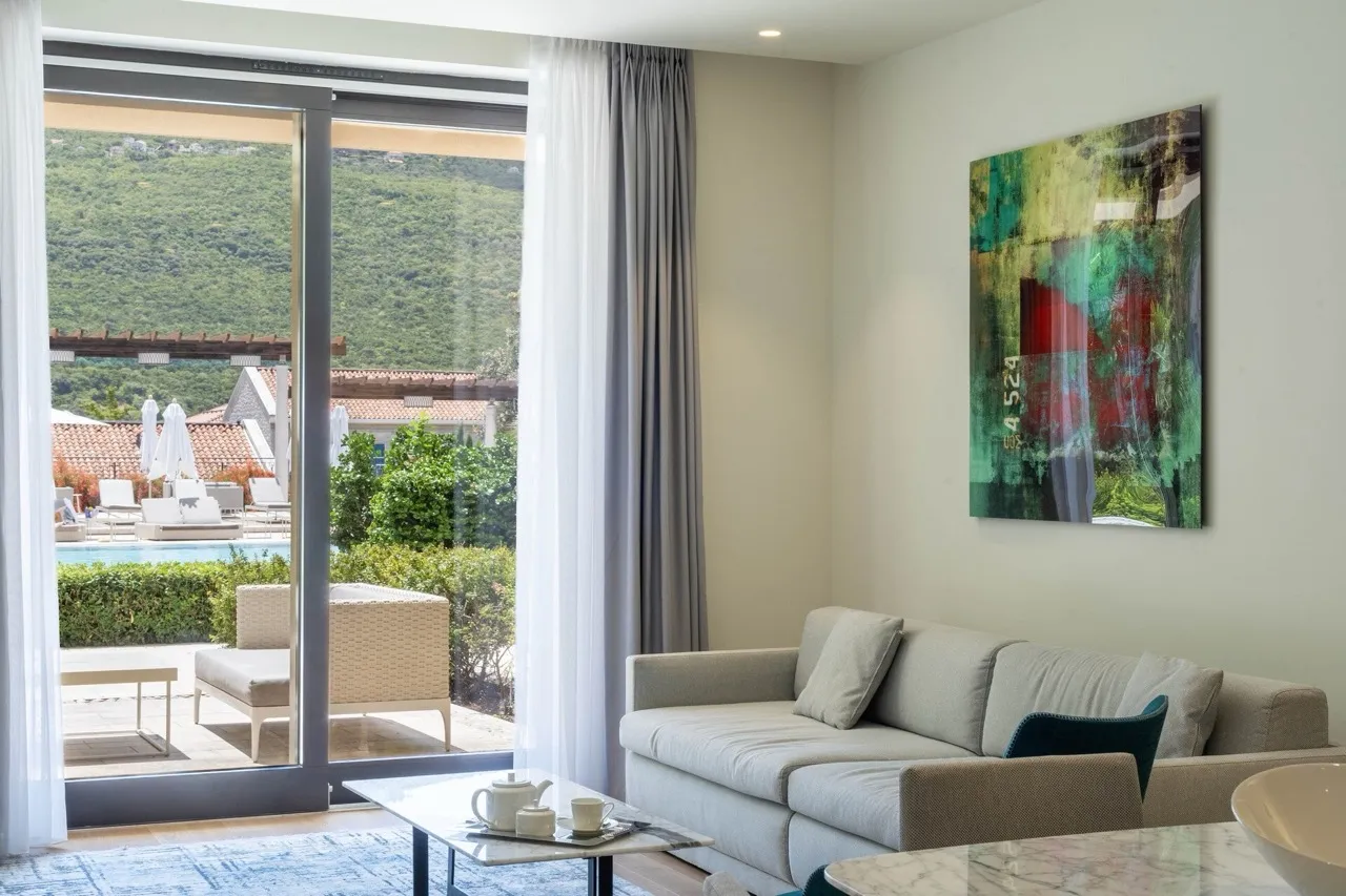 Wohnzimmer mit Panoramablick auf den Pool in den Portonovi-Apartments, Kumbor, Montenegro: modernes Interieur mit Sofa.