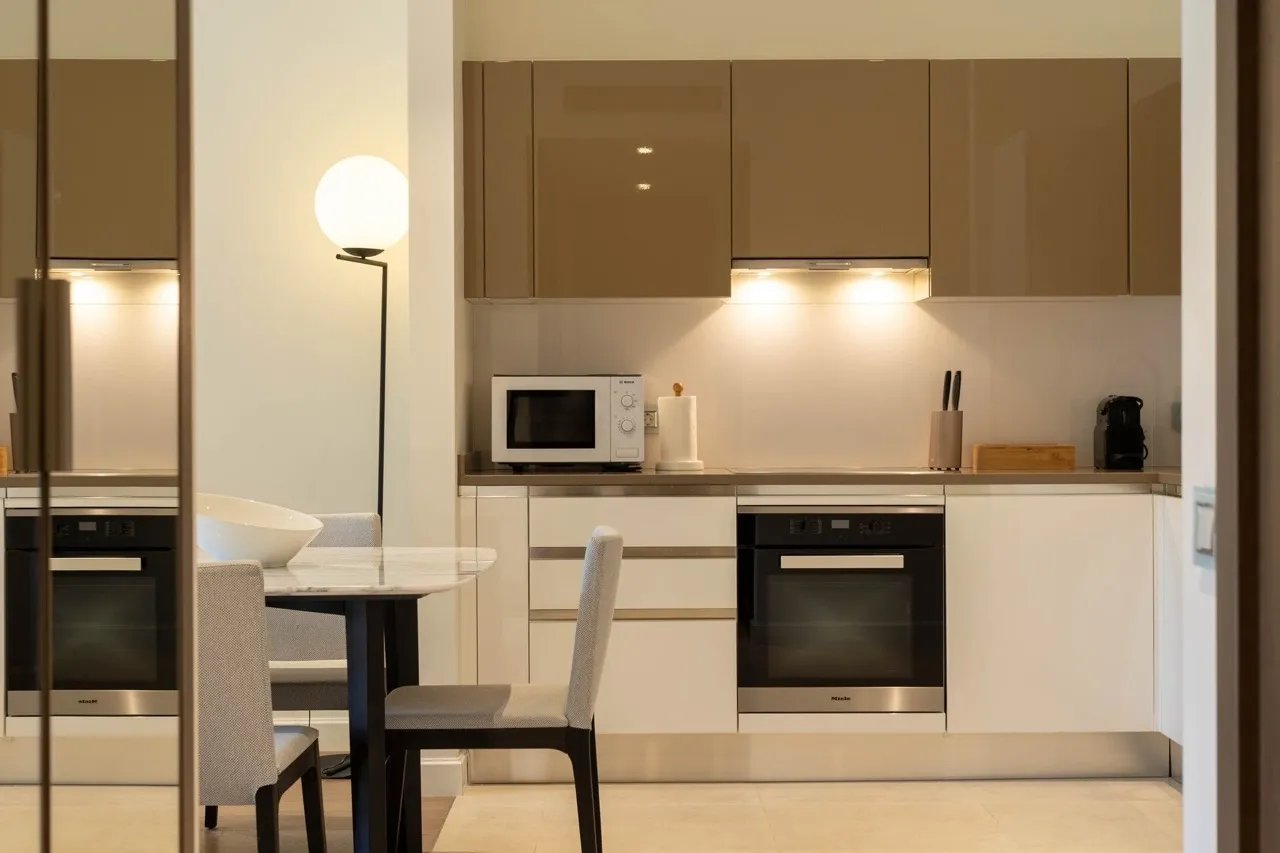 Moderne Küche in der Wohnung Portonovi, Kumbor, Montenegro: Hochglanzfronten, Miele-Geräte und Essbereich.
