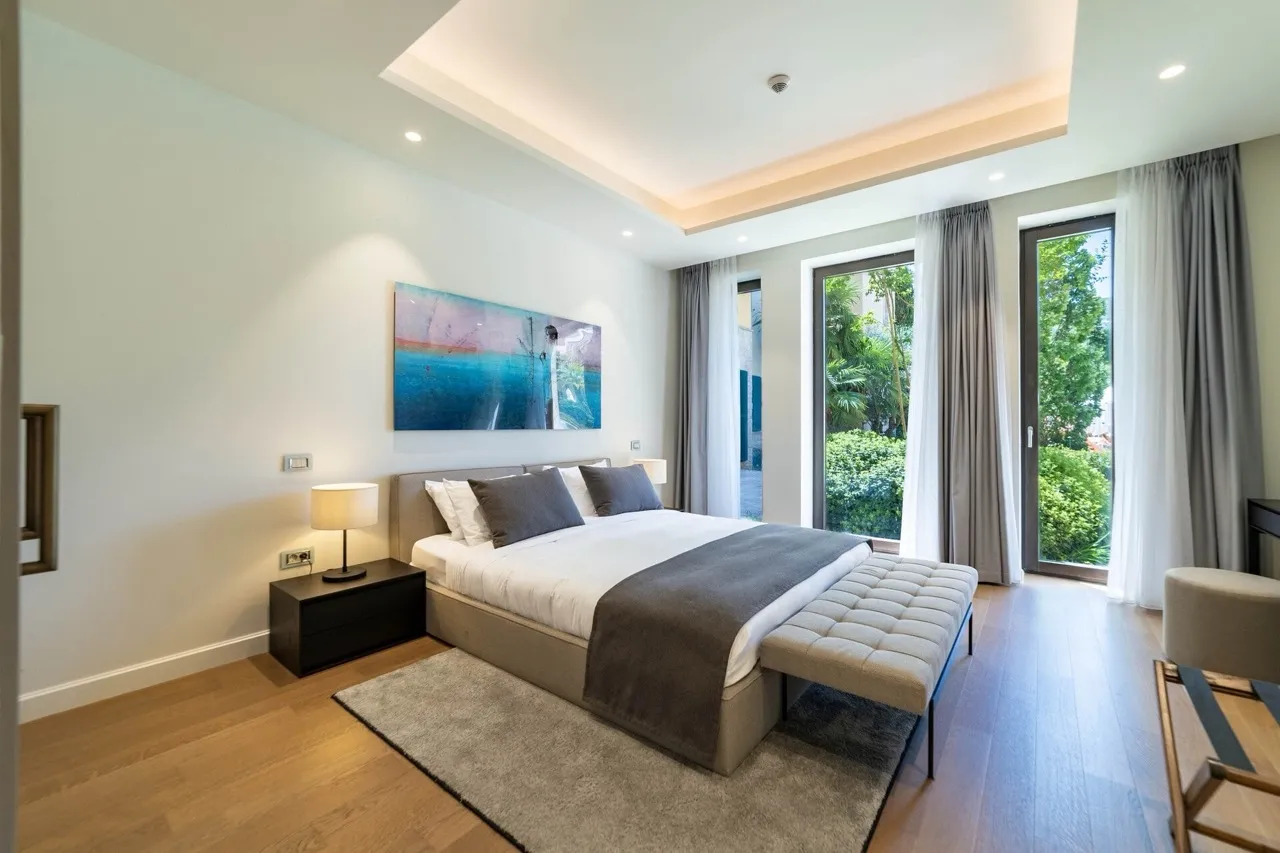 Modernes Schlafzimmer in der Wohnung Portonovi, Kumbor, Montenegro: Doppelbett, Panoramafenster und Blick auf den Garten.