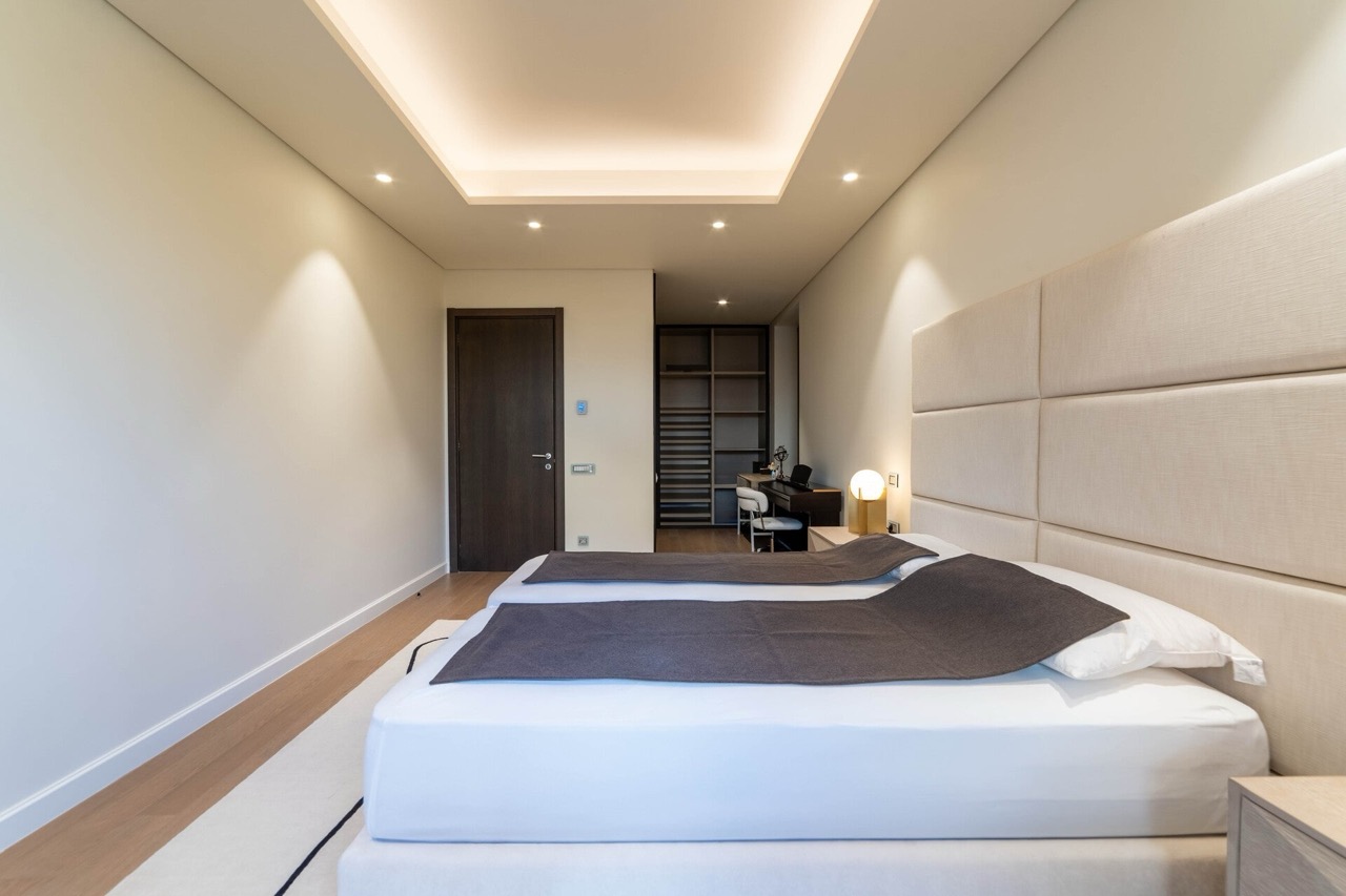 Modernes Schlafzimmer in der Wohnung Portonovi, Kumbor, Montenegro: Doppelbett, gepolstertes Kopfteil und Ankleidezimmer.