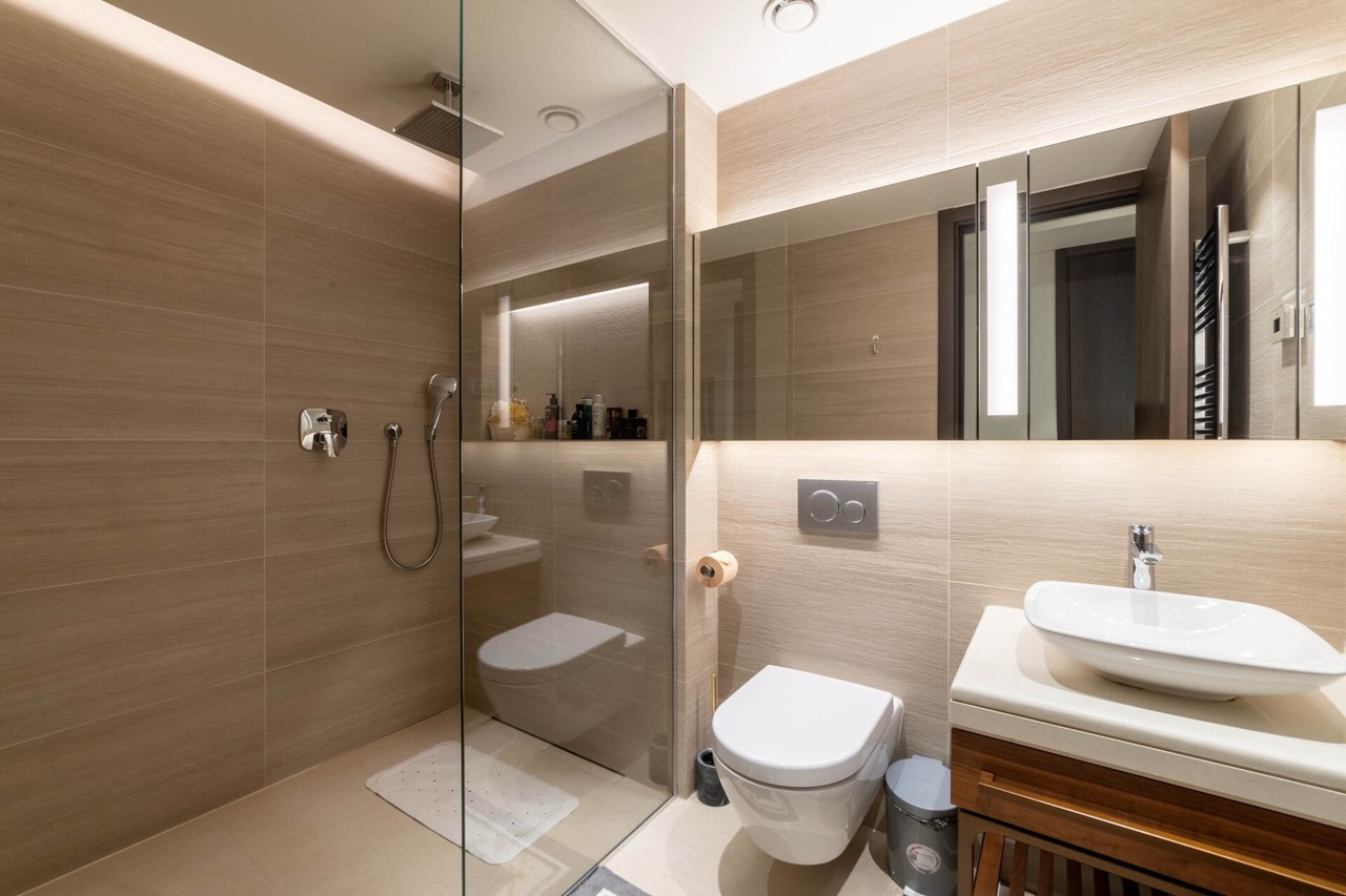 Modernes Badezimmer in der Wohnung Portonovi, Kumbor, Montenegro: Duschkabine, stilvolle Sanitäranlagen und Beleuchtung.