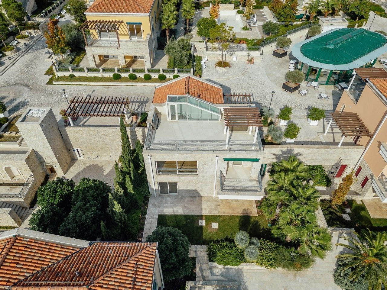 Top view of a villa in Portonovi, Kumbor, Montenegro: stone finish, terrace, panoramic roof, and landscaped garden.