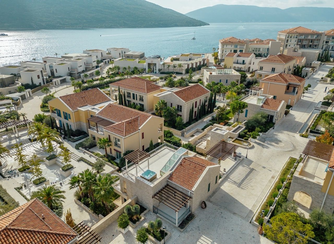 Aerial view of the luxury Portonovi resort in Kumbor, Montenegro: villas with tiled roofs and terraces with jacuzzis.