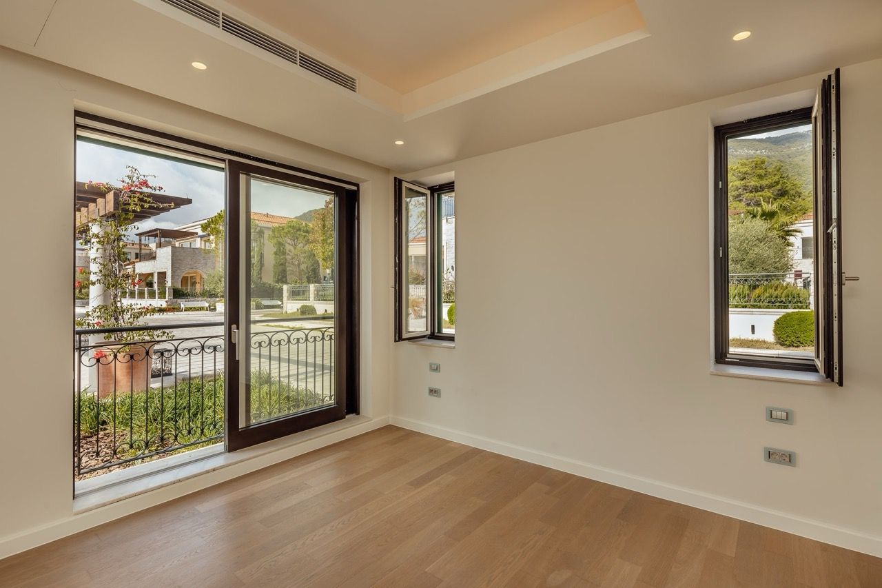 Bright living room with panoramic windows and a view of the garden in an exclusive villa in Portonovi, Kumbor, Montenegro.