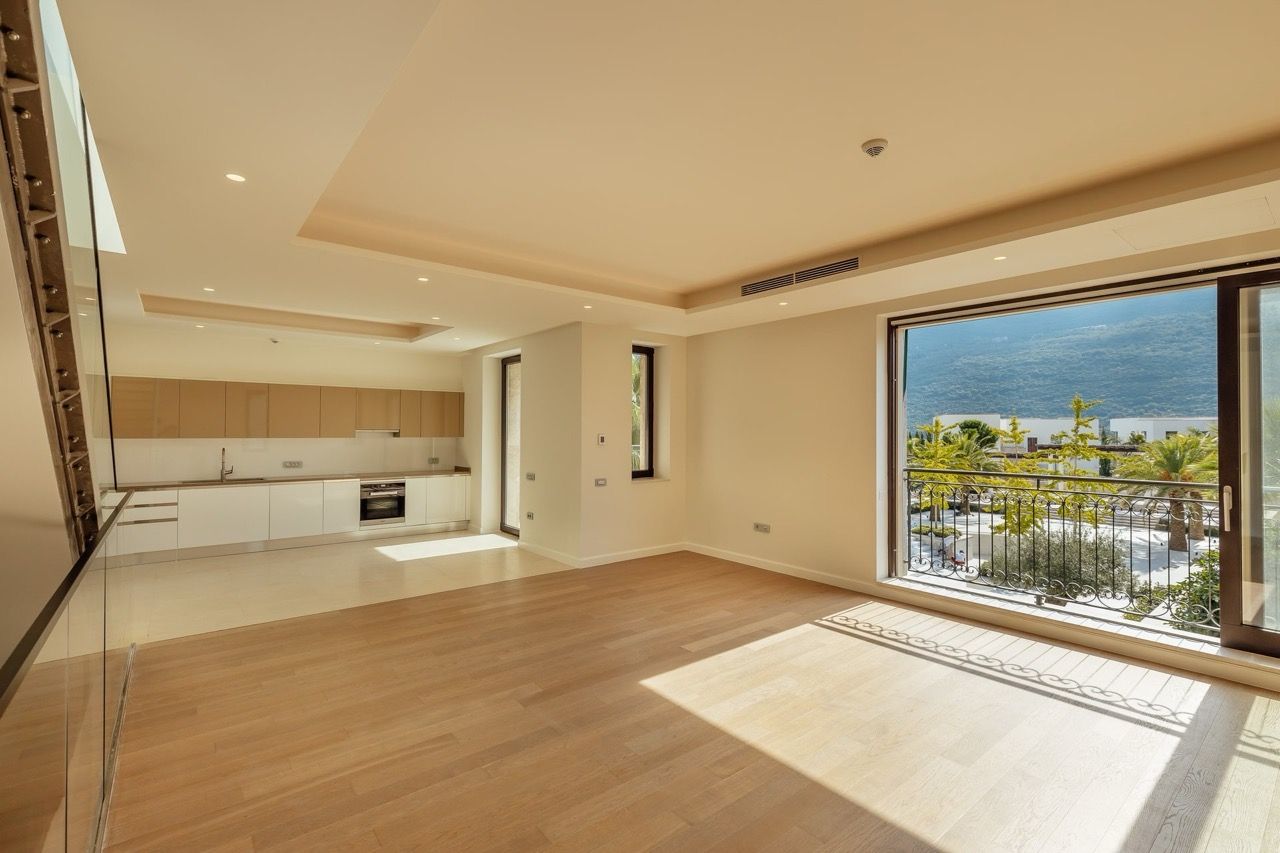 Spacious living room with kitchen in a villa in Portonovi, Kumbor, Montenegro: panoramic windows, mountain views, and modern design.