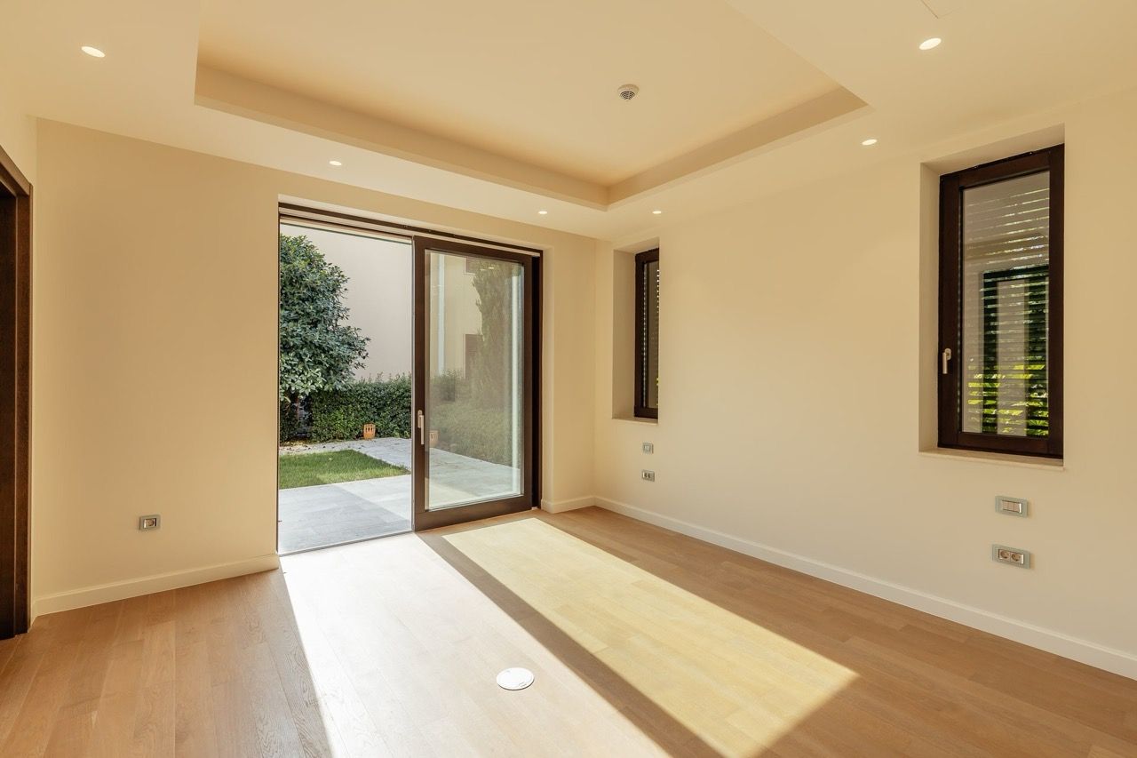 Bright living room with access to the terrace and garden in a villa in Portonovi, Kumbor, Montenegro: modern finishes and parquet flooring.