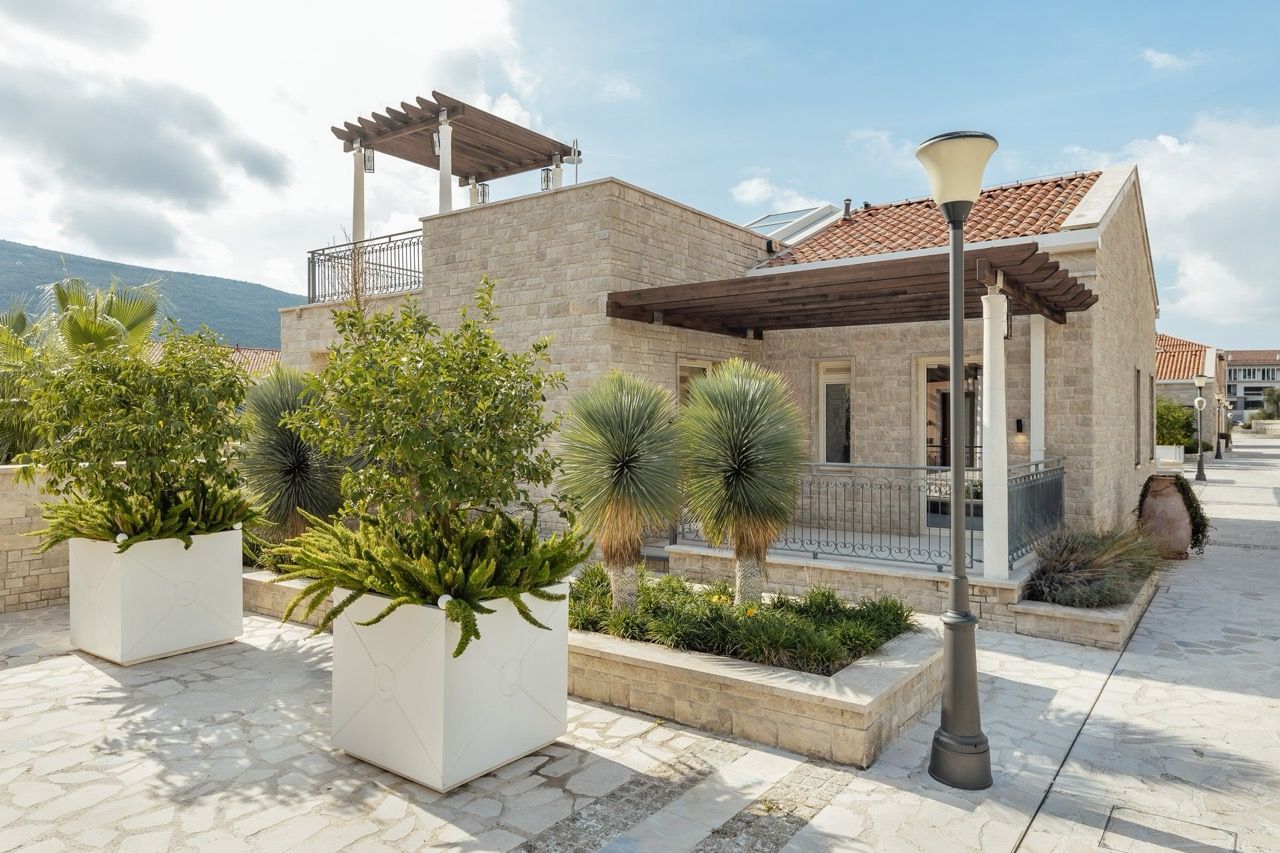 Stone villa in Portonovi, Kumbor, Montenegro: terrace with pergola, landscaped design, and view of the Mediterranean garden.