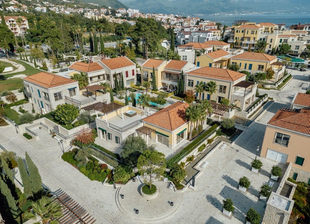 Aerial view of a luxury villa complex in Portonovi, Kumbor, Montenegro: tiled roofs, a swimming pool, and landscaping.