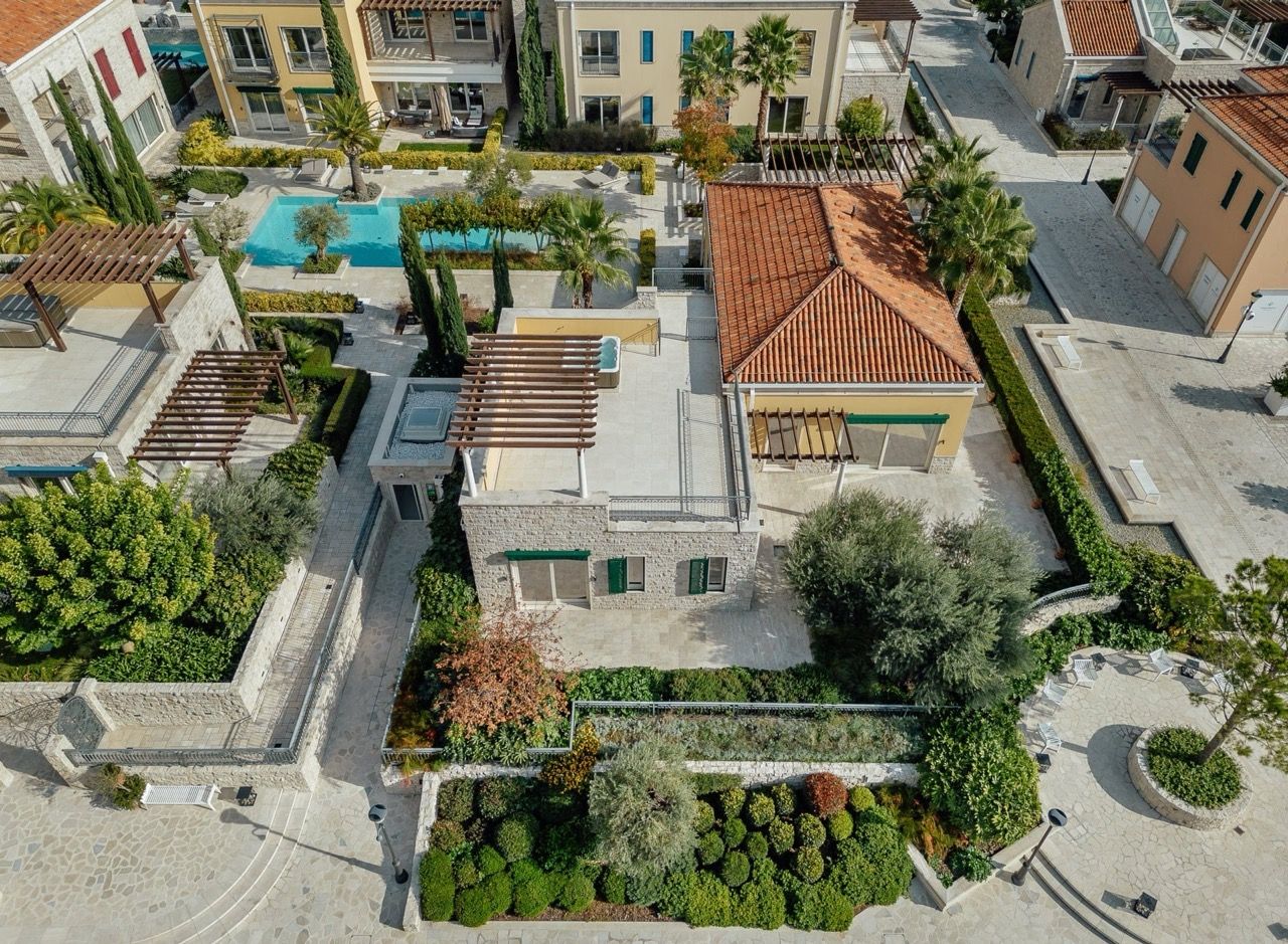 Aerial view of a villa in Portonovi, Kumbor, Montenegro: terrace with jacuzzi, pool, and the complex’s landscaped grounds.