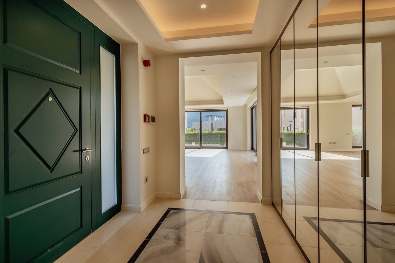 Villa hallway in Portonovi, Kumbor, Montenegro: green front door, mirrored wardrobe, and a view of the terrace.