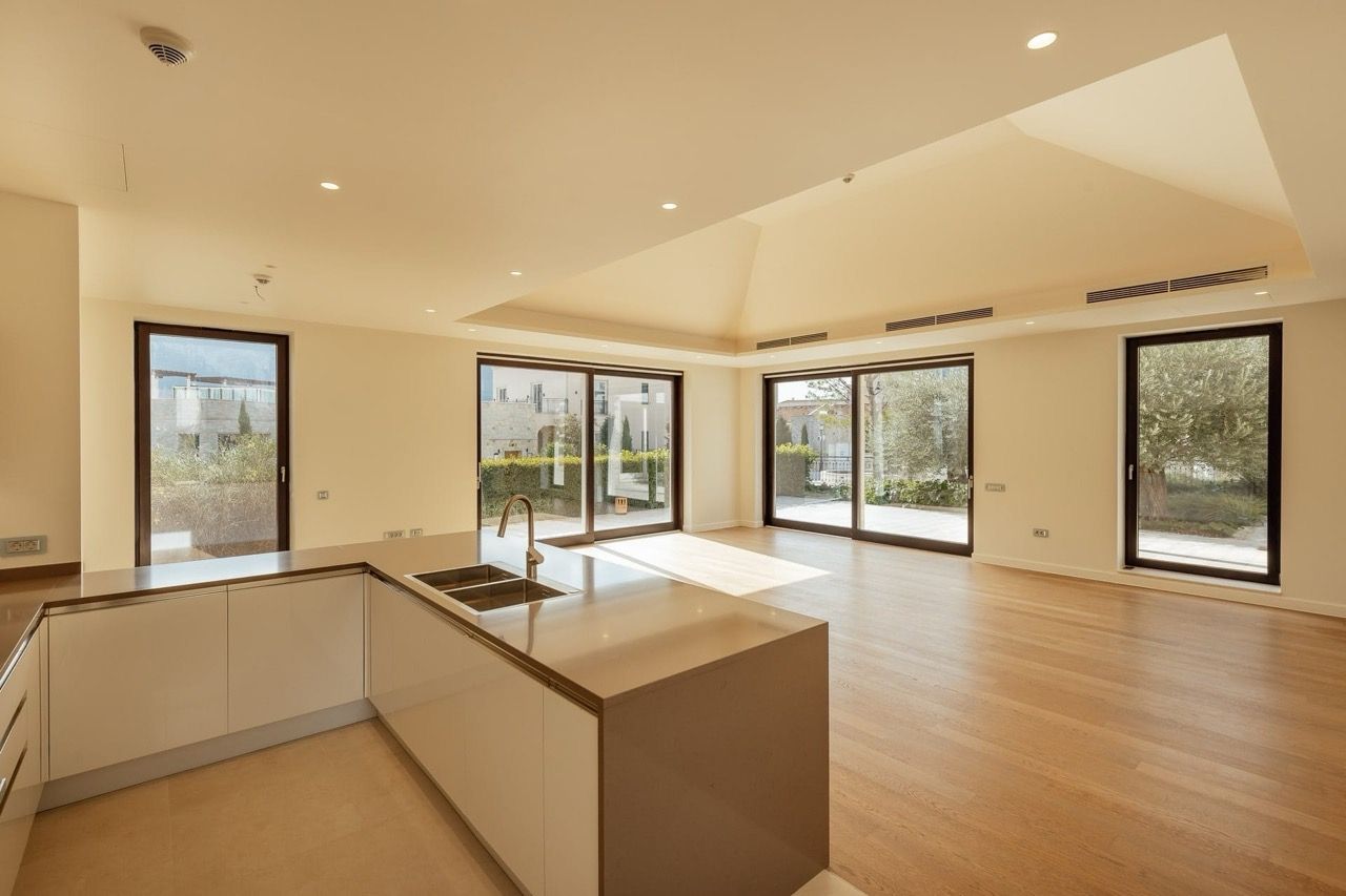 Modern kitchen-living room in a villa in Portonovi, Kumbor, Montenegro: panoramic windows, bright interior, and an island.