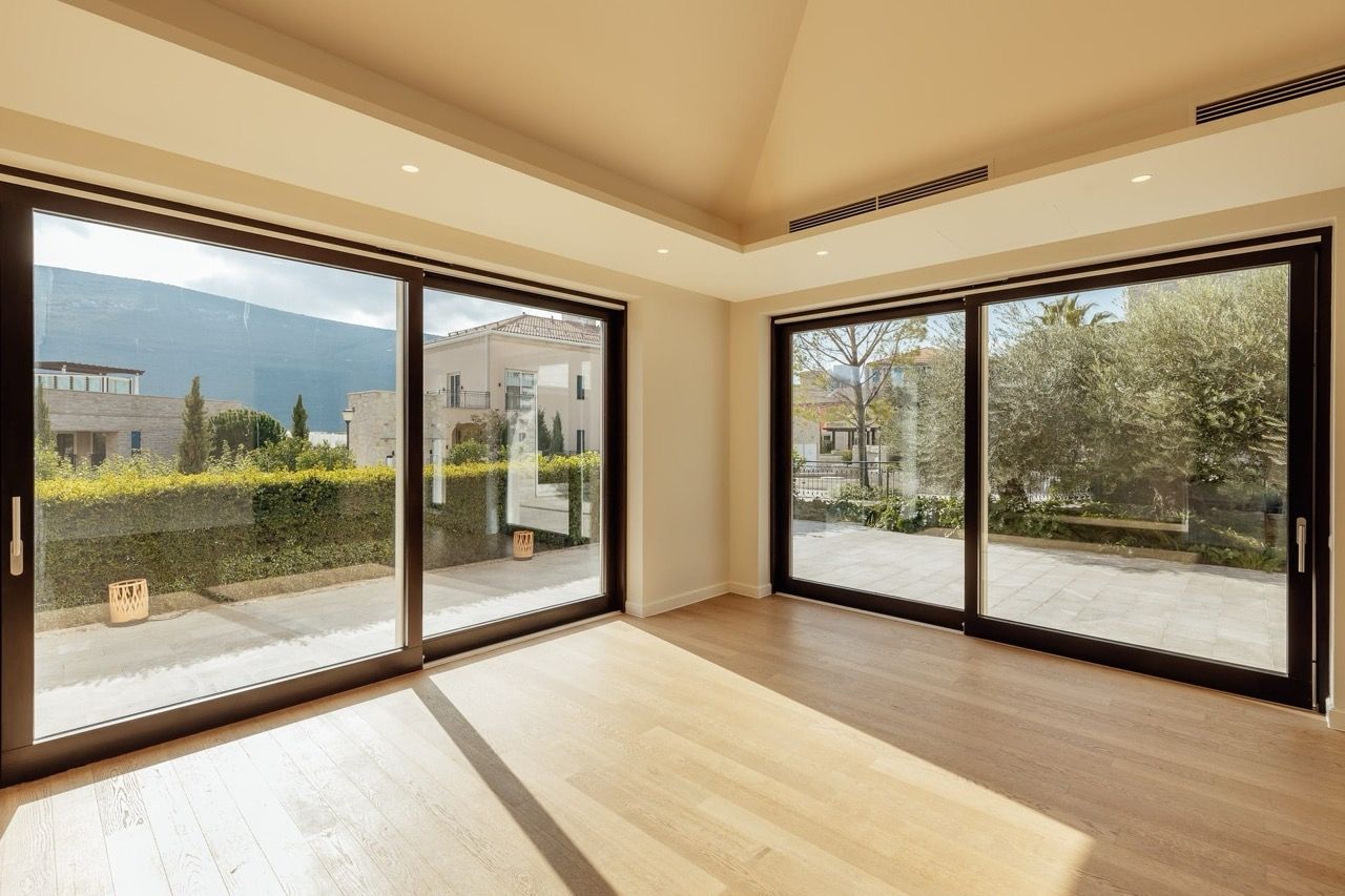 Living room with panoramic windows and mountain views in the Portonovi villa, Kumbor, Montenegro: modern interior and terrace.