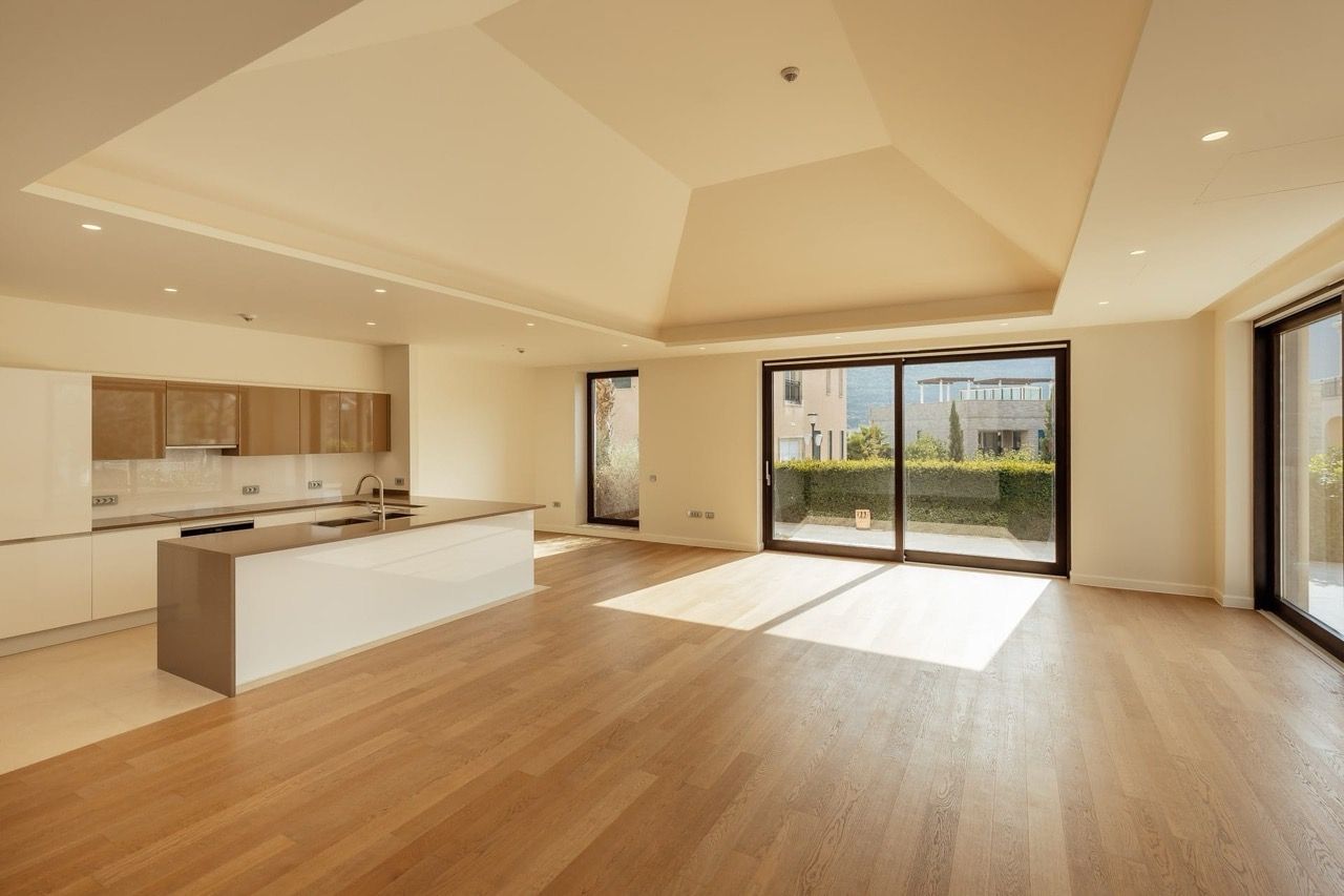 Modern kitchen-living room with panoramic windows in a villa in Portonovi, Kumbor, Montenegro. Bright interior with an island.