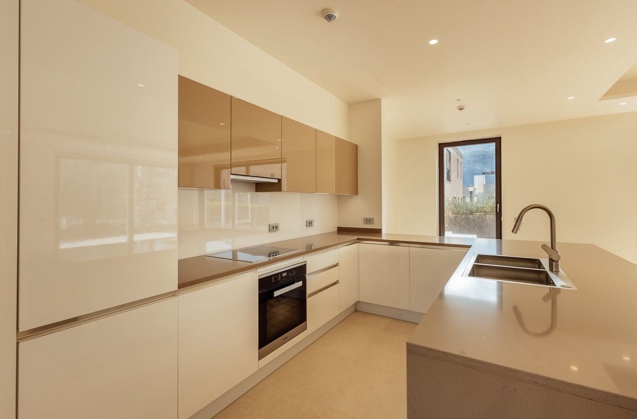 Modern kitchen with white glossy cabinets and an island in a villa in Portonovi, Kumbor, Montenegro.