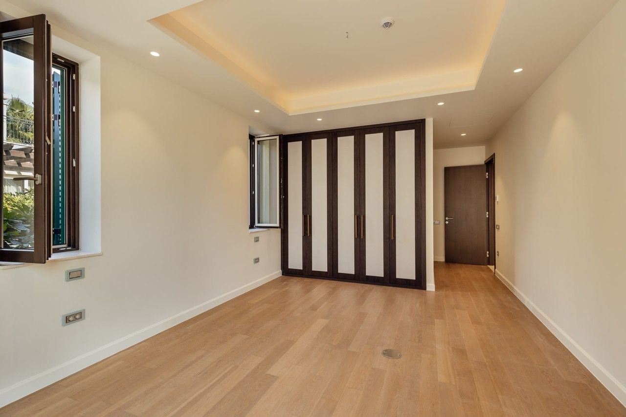 Bedroom in a villa in Portonovi, Kumbor, Montenegro: modern interior, built-in wardrobe, parquet flooring, and garden view.