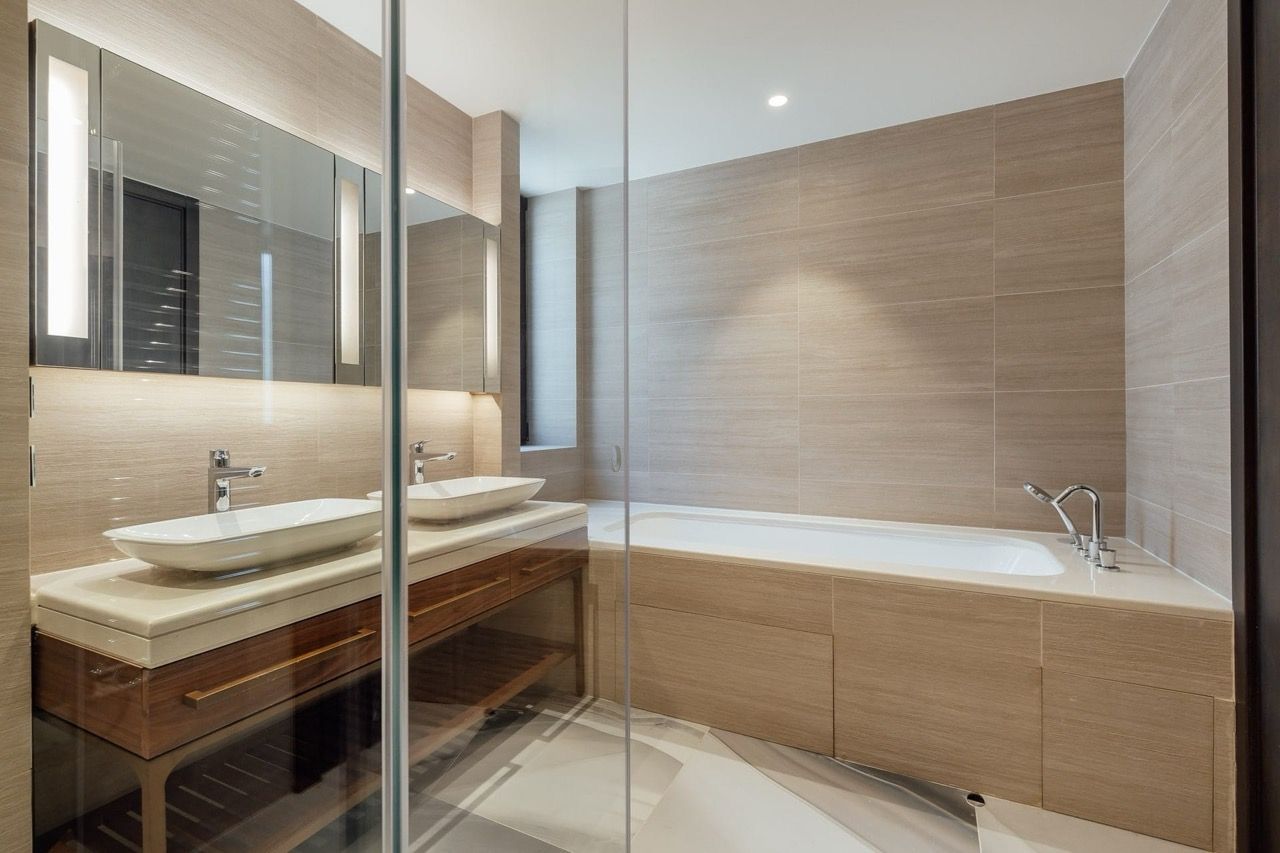 Modern bathroom with two sinks and a bathtub in a villa in Portonovi, Kumbor, Montenegro. Wood finish.