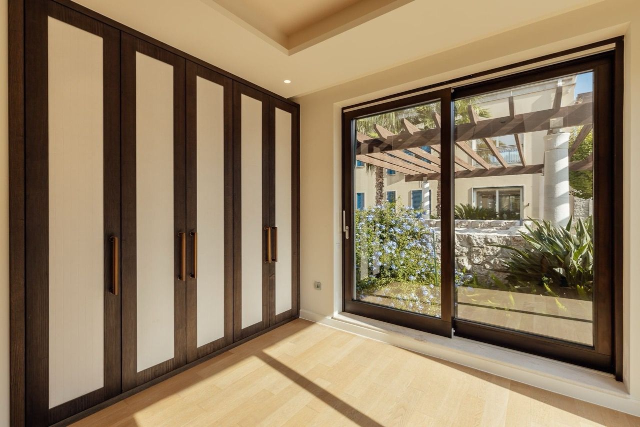 Bedroom with a panoramic window and built-in wardrobe in a villa in Portonovi, Kumbor, Montenegro: modern interior.
