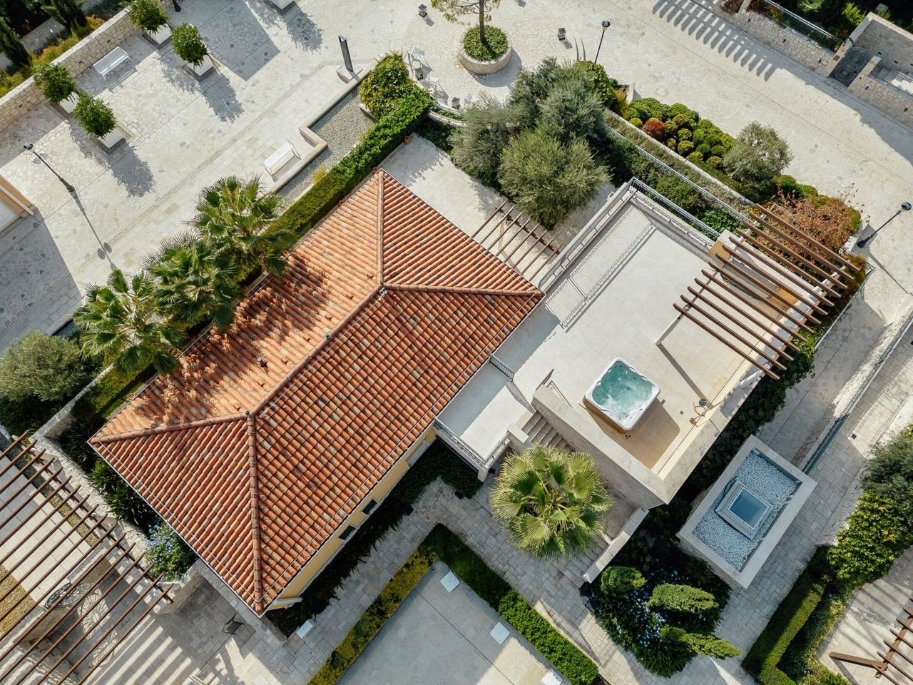 Top view of a villa in Portonovi, Kumbor, Montenegro: tiled roof, terrace with jacuzzi, and landscaped design.