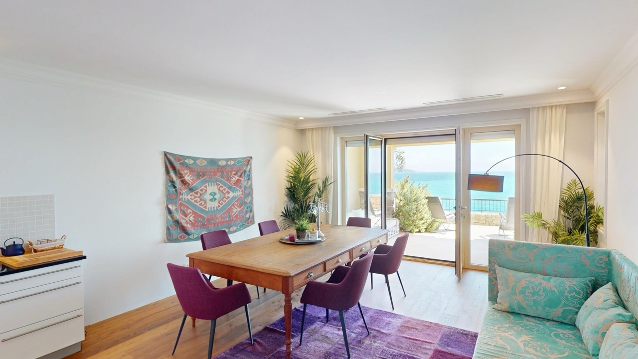 Wohnzimmer mit Essbereich in der Wohnung Luštica Bay, Radovići, Montenegro: Meerblick, Holztisch und Terrasse.