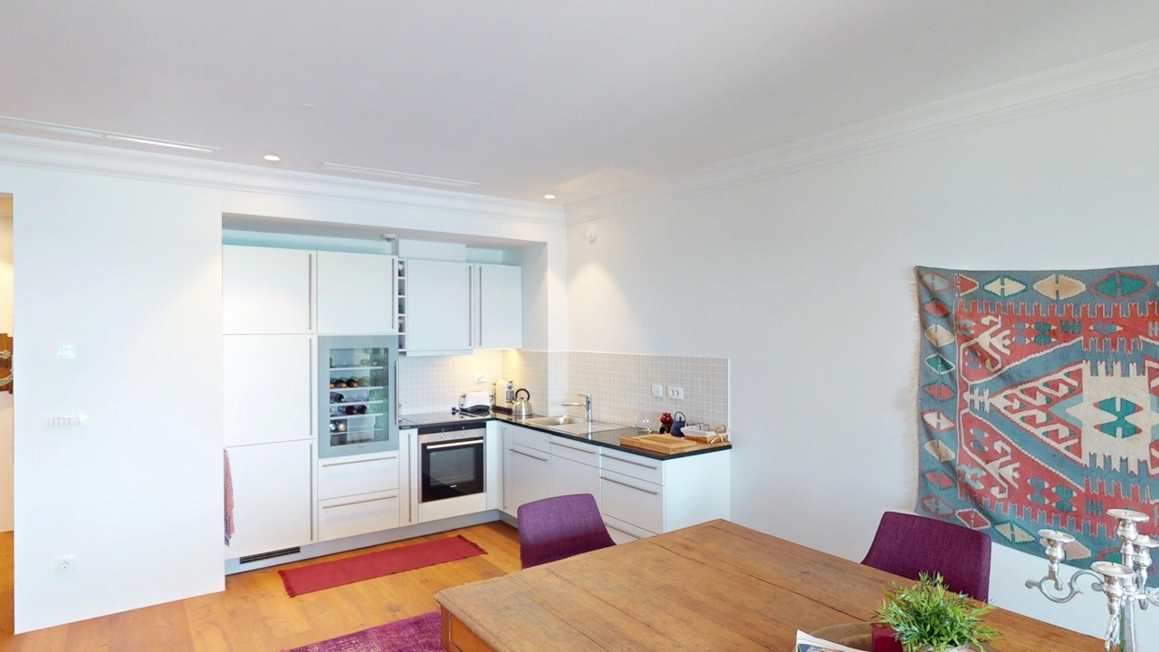 Moderne Küche mit Weinschrank in der Wohnung Lustica Bay, Radovici, Montenegro: helle Einbauküche und Essbereich.